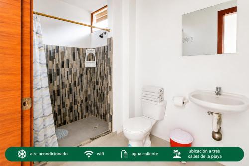 a bathroom with a shower and a toilet and a sink at Suites Villa Colombia in Puerto López