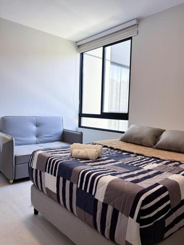 a bedroom with a large bed and a couch at Aura Exclusive - Achumani in La Paz