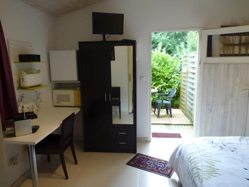 a bedroom with a bed and a desk with a mirror at Chambre D'hôtes Indépendante in Pessac