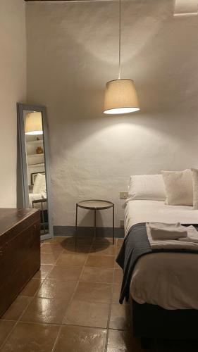 a bedroom with a bed and a table and a light at Window to Bagno Vignoni in Bagno Vignoni