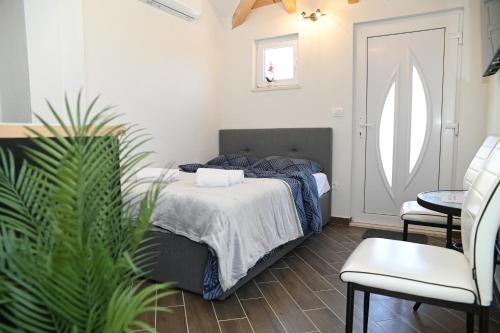 a bedroom with a bed and a potted plant at Casa De Hijos in Cavtat