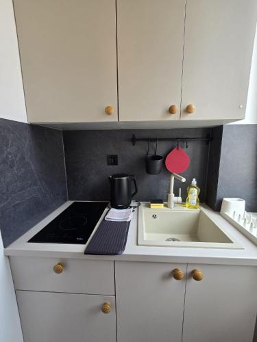 a white kitchen with a sink and a stove at Studio Apartments - Pula city center in Pula