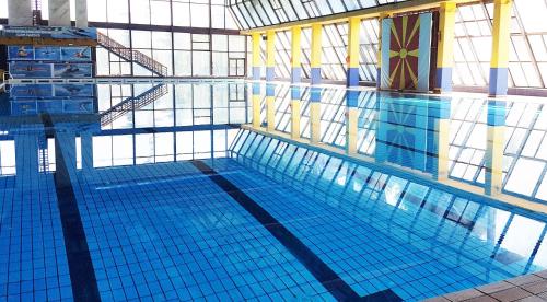 a large swimming pool with blue tiles in a building at Hotel Centar in Skopje