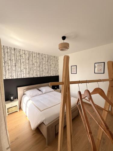 a bedroom with a bed and two wooden chairs at Gite Ô’Violetis in Domvast