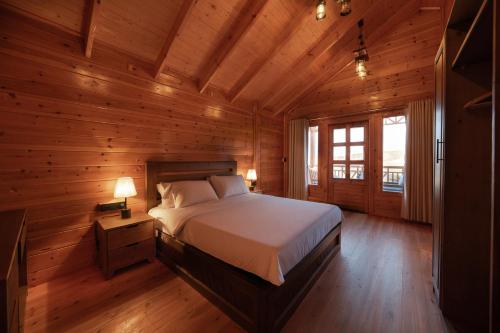 a bedroom with a bed in a wooden cabin at اكواخ مشارف ابها in Mahlal