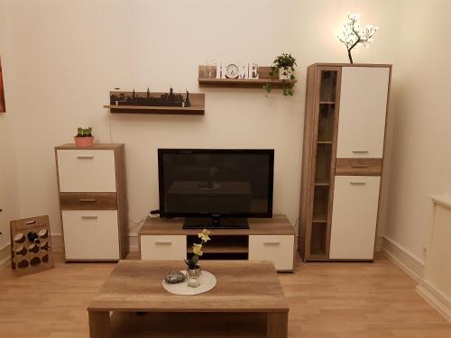 ein Wohnzimmer mit einem TV und einem Couchtisch in der Unterkunft City Apartment in Düren - Eifel