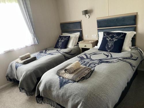 a bedroom with two beds with blue pillows at Edmonton Lodge in Clitheroe