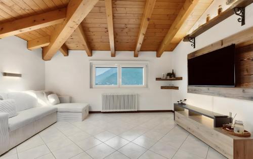a living room with a flat screen tv and a couch at Mansarda Spadone in Musso