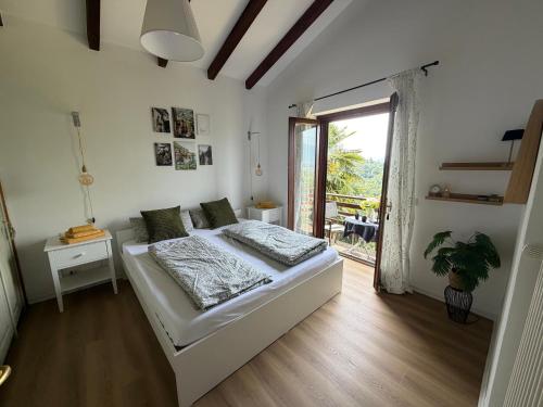 a bedroom with a bed and a large window at Rustico Villa Antonia with seaview and pool in Bieno