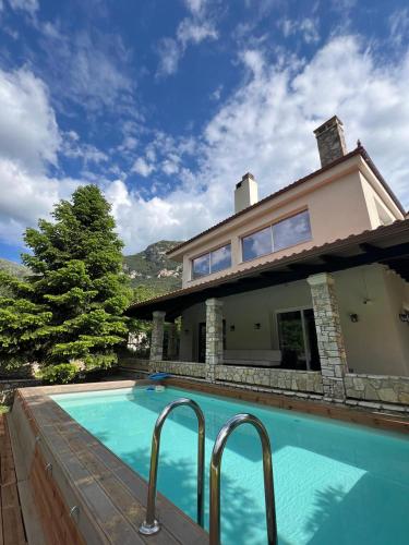 a house with a swimming pool in front of a house at eleni's villa in Kandhíla