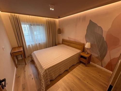 a bedroom with a bed and a large leaf painted on the wall at City View Apartment in Râmnicu Vâlcea