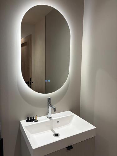 a bathroom with a white sink and a mirror at City View Apartment in Râmnicu Vâlcea