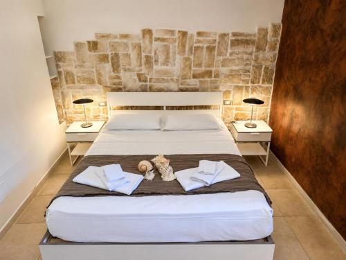 a bedroom with a large bed with two lamps at Ulìa - Stone house tra borgo antico e mare in Giovinazzo