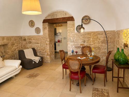 a living room with a table and a couch at Ulìa - Stone house tra borgo antico e mare in Giovinazzo
