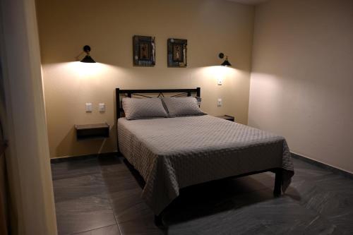 a bedroom with a bed and two lights on the wall at Casa Tita in Acámbaro