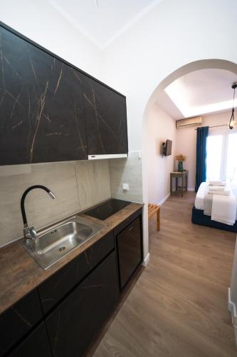 a kitchen with a sink and a room with a bed at Panorama Hideaway in Dassia