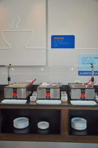 a kitchen counter with plates and appliances on it at Holiday Inn Express Hotel & Suites Hermosillo by IHG in Hermosillo