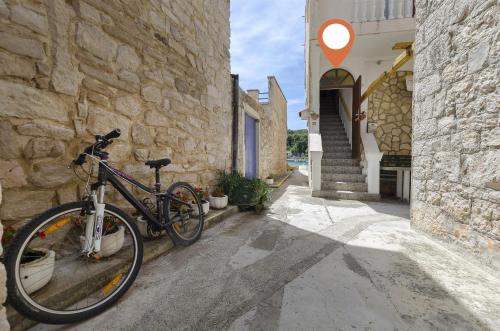 a bike parked next to a stone building at Apartment Mirni by the sea in Prvić Luka