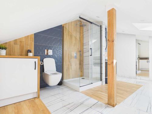 a bathroom with a toilet and a glass shower at Radość z Marzeń in Suwałki