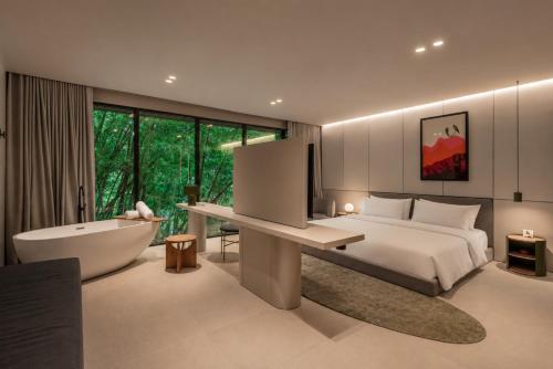 a bedroom with a bed and a bath tub and a bath tub at Wake BioHotel, a Member of Design Hotels in Medellín