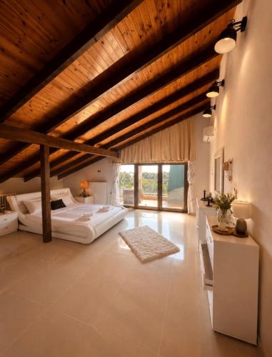 a large bedroom with a bed and a wooden ceiling at SkyVista Villa in Iraklitsa