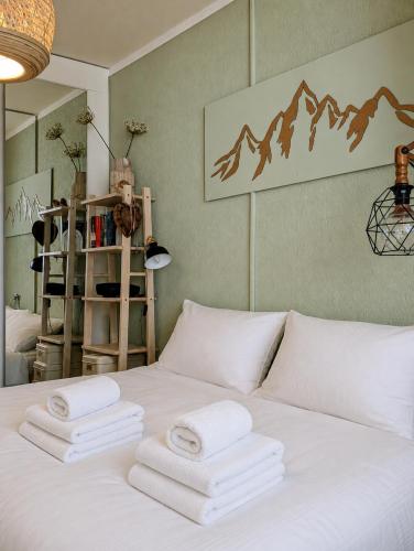 a white bed with three towels on top of it at Residenz Majesta Leukerbad in Leukerbad