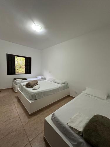 a bedroom with two beds and a window at Chácara porta do sol in Mairinque