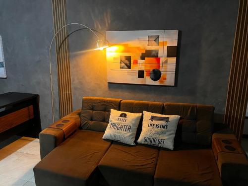 a living room with a brown couch with two pillows at Smart & Comfort 4 - Ap completo in Campina Grande