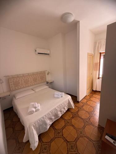 a bedroom with a bed with towels on it at Casa dei mille in Castelsardo