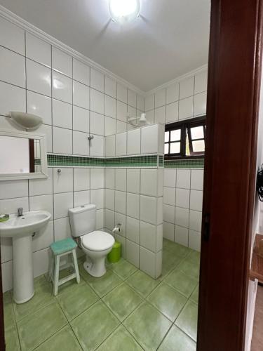 a bathroom with a white toilet and a sink at Chácara porta do sol in Mairinque
