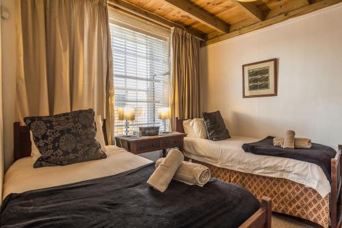 a bedroom with two beds and a window at Bartholomew's Loft in Grahamstown