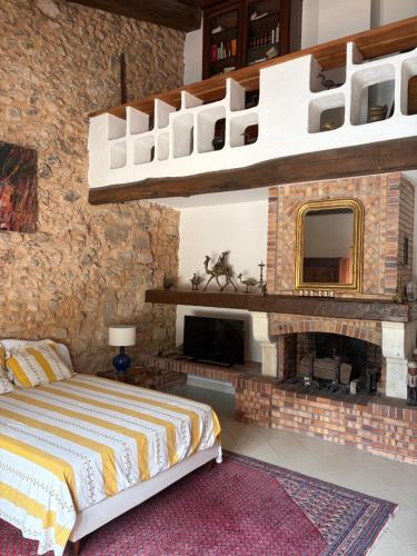 a bedroom with a brick wall with a bed and a fireplace at La Gran Vigne in Salernes