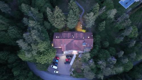 Eine Draufsicht auf ein Haus mit im Wald geparkten Autos in der Unterkunft Hotel Montegrino Lakeview in Montegrino Valtravaglia
