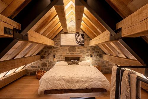 a bedroom with a large bed in an attic at Buron du Tournel, un écrin d'exception in Le Lioran