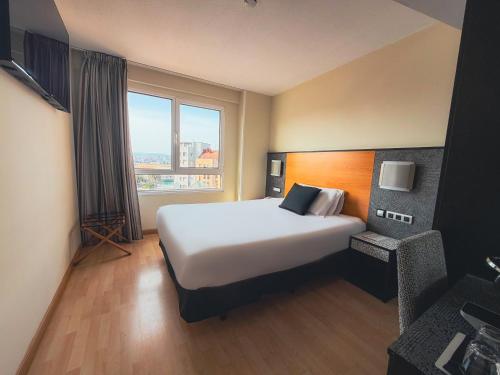 a hotel room with a large bed and a window at Hotel Faranda Pathos Gijón, Ascend Hotel Collection in Gijón