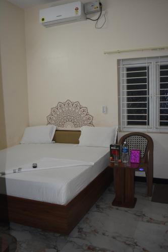 a bedroom with a bed and a table and a window at Hotel KGR in Palni