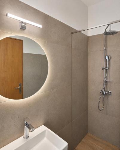 a bathroom with a sink and a mirror at H Stella Apartments & Rooms in Kalamitsi