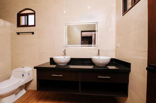 a bathroom with two sinks on a black counter at Pedasi, Casa Limon - 2 BD in Purio