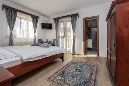 a bedroom with a bed and a large window at Casa Bocskai-Vendégház in Sovata