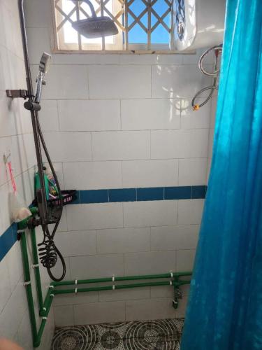 a shower in a bathroom with a shower curtain at Happy Lodge in Sakumona