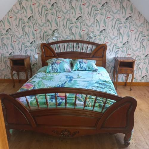 a wooden bed in a room with two tables at Le paradis sur mer in Paimpol