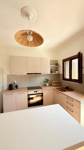 a kitchen with white cabinets and a ceiling at Casa SanGiorgio Stone Villas with Sea View in Skaltsotiánika