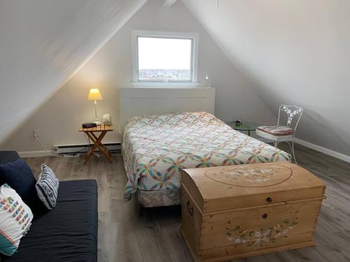 a bedroom with a bed and a table and a window at Pet-Friendly Private Beach Oceanfront Cottage in Charlestown