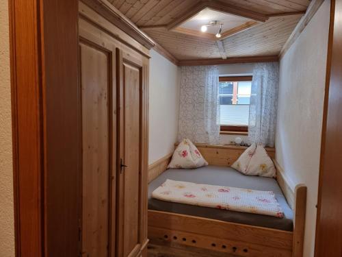 a small bed in a tiny house with a window at Ferienwohnungen Zinzlerbauer in Uttendorf