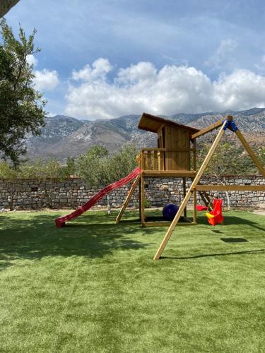 a playground with a swing set in a yard at Casa SanGiorgio Stone Villas with Sea View in Skaltsotiánika