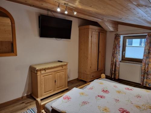 a bedroom with a bed and a tv on the wall at Ferienwohnungen Zinzlerbauer in Uttendorf