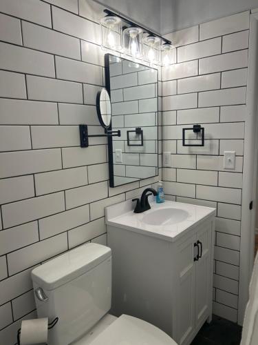 a bathroom with a sink and a toilet and a mirror at Serenity Landing in Sioux Falls