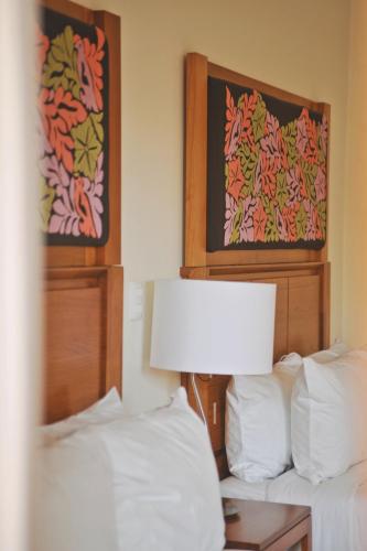 a bedroom with two beds and a table with a lamp at XTILU Hotel - Adults only - in Oaxaca City