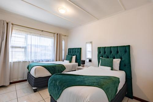 a hotel room with two beds and a window at Safi Luxury Self-Catering Suite 8 in East London