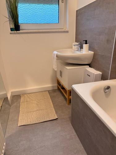 a bathroom with a sink and a bath tub at Ferienwohnung Weinrebe in Oppenheim